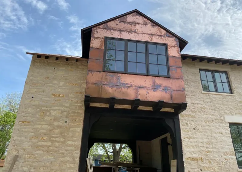 Copper metal panel facade on a stone building for Skylight Installation in West Bend